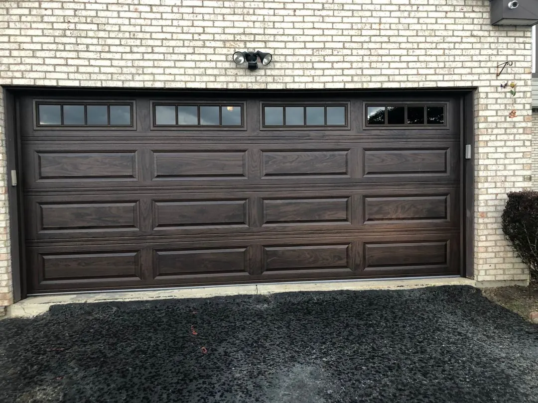 Dark brown door on a white brick home