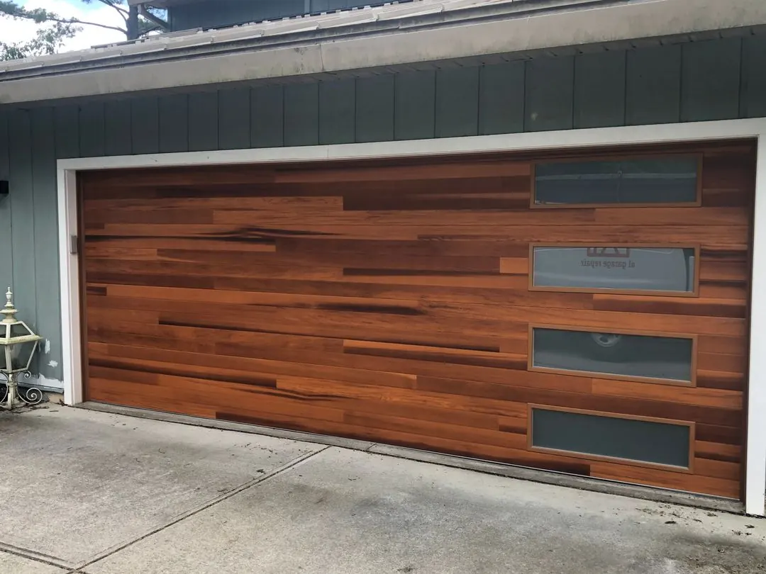 Modern wood-look garage door with a column of frosted windows