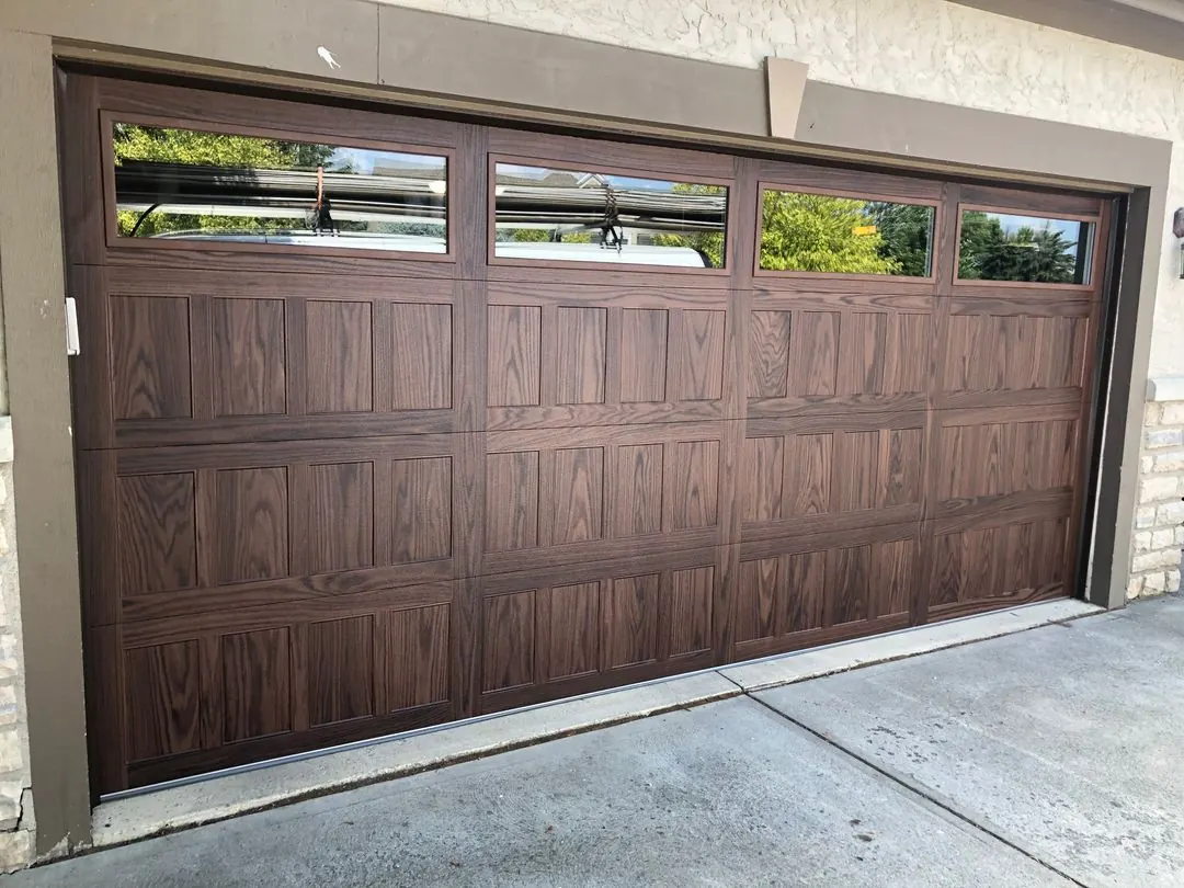 Walnut-look garage door with a row of windows