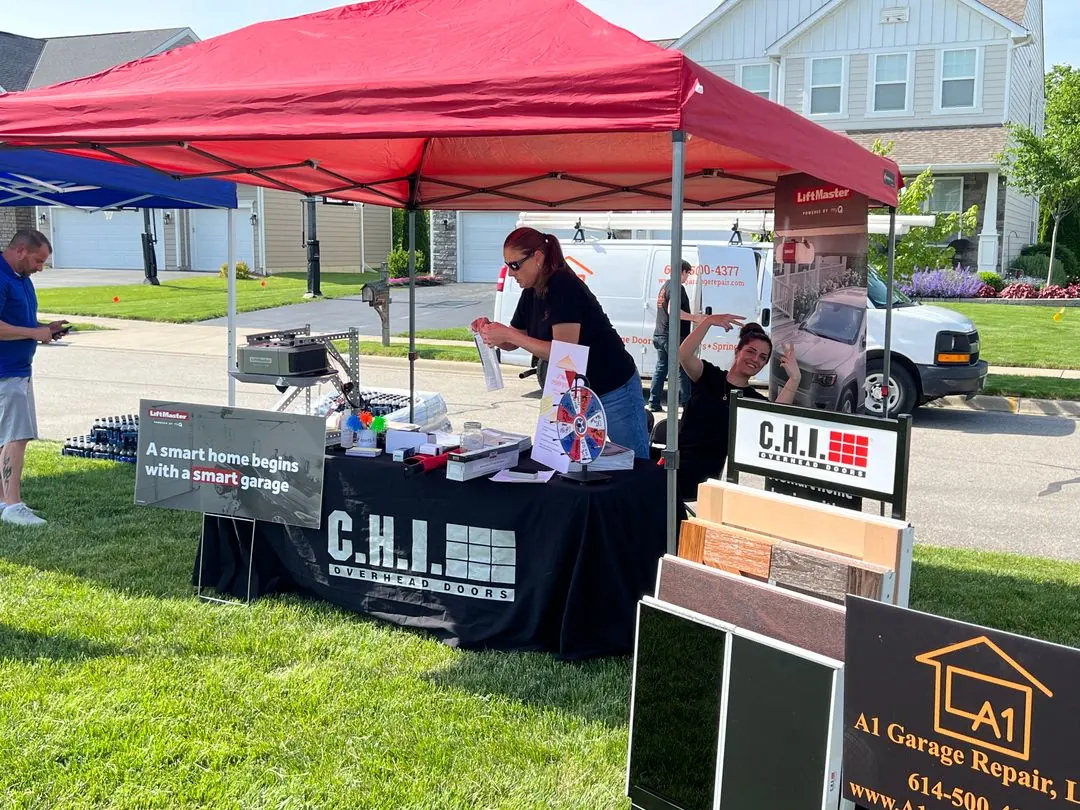 A1 Garage Repair booth with door samples under a red canopy at a community event