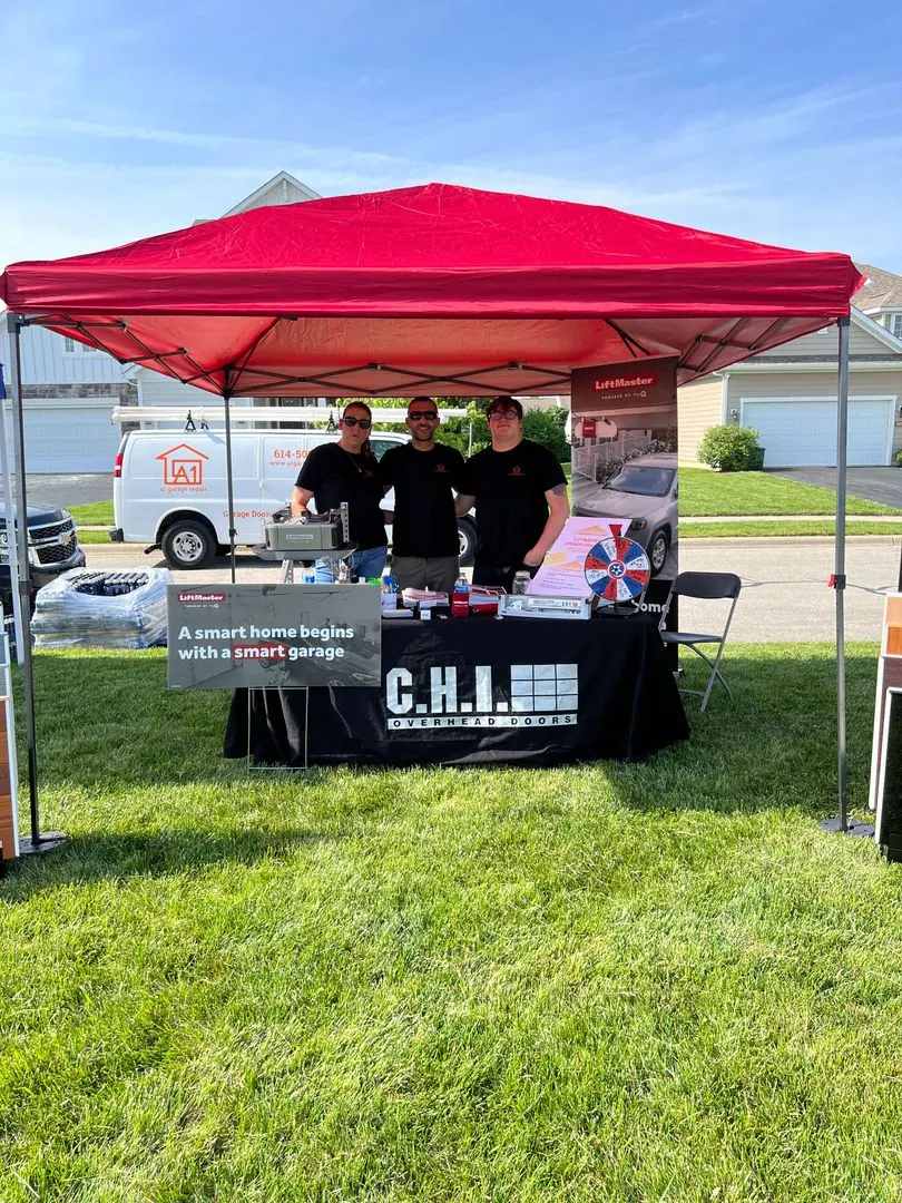 A1 Garage Repair booth under a red canopy at a neighborhood event